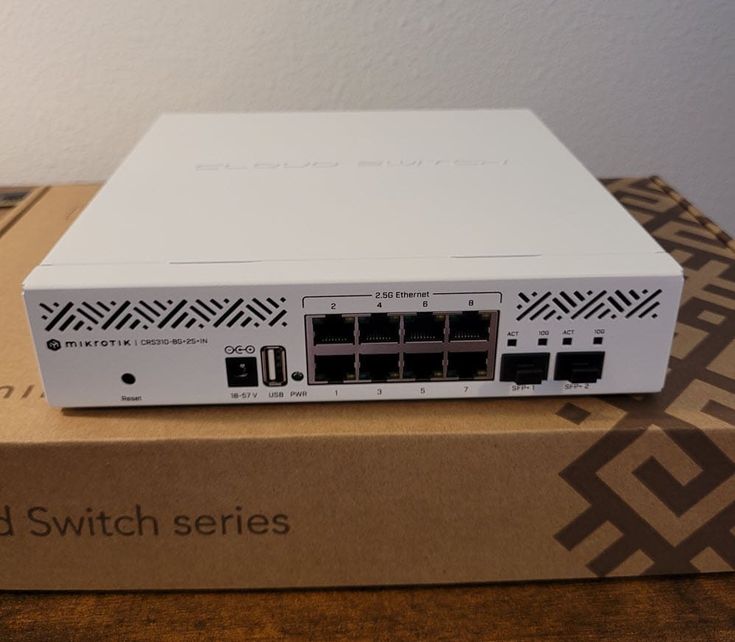 MikroTik CRS310-8G+2S+IN 8-Port 2.5G Cloud Router Switch showing front panel with 2.5G Ethernet ports, 2x SFP+ uplinks, USB port and reset button — Cloud Switch Series retail box in background